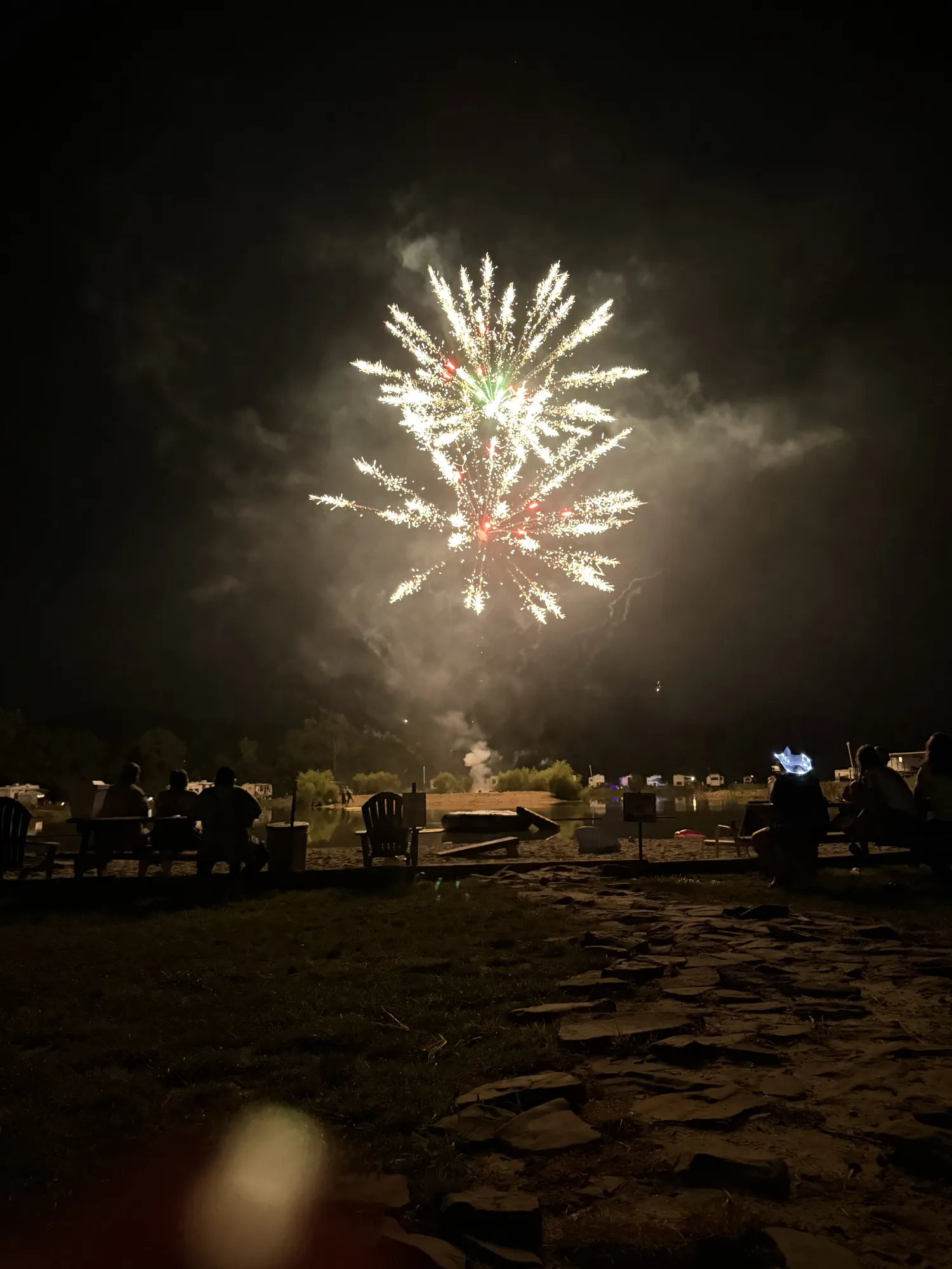 Fireworks over the lake with RVs along the far shore