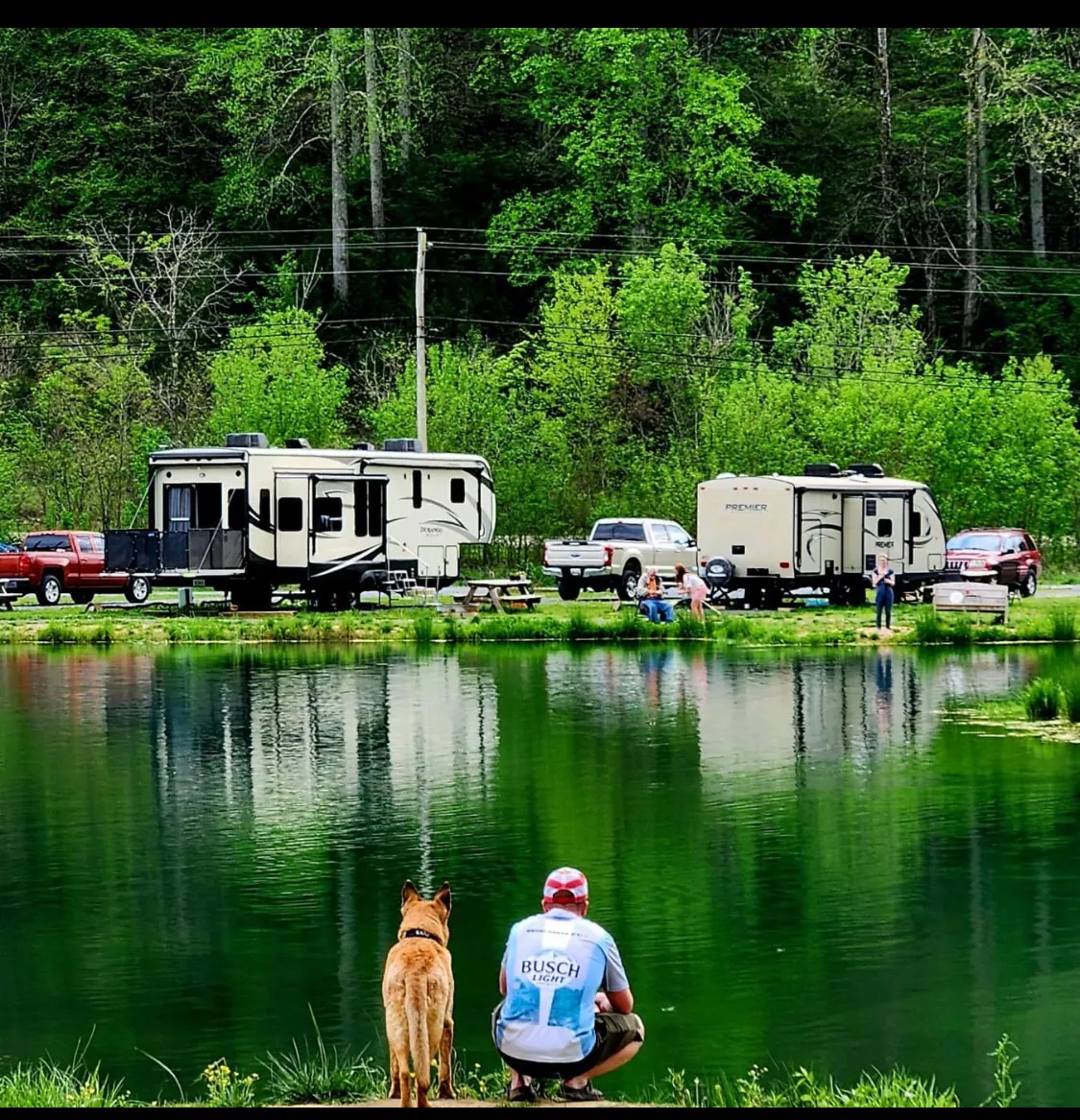 Guest and dog overlooking lakefront RV sites